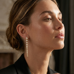woman with long gold plated earrings